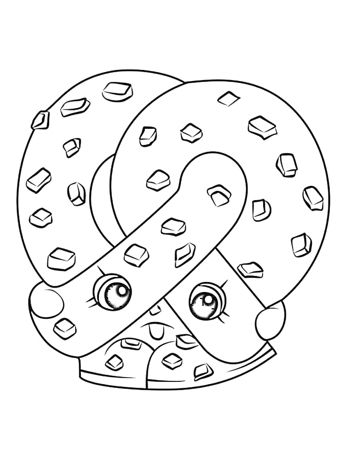 Пряник в форме кренделя с глазами и бровями, украшенный квадратными кусочками