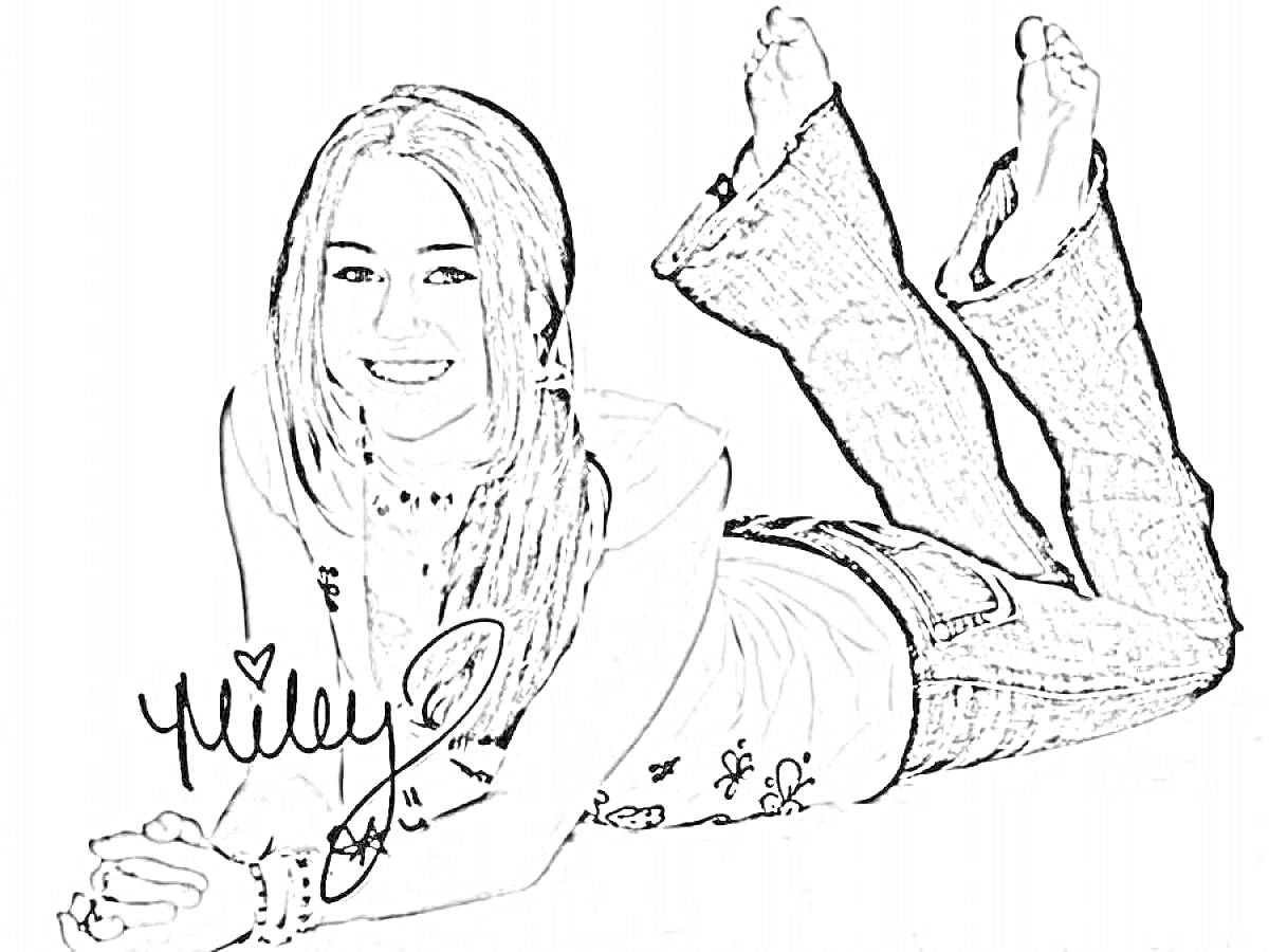 Девушка в джинсах с рисунком в виде сердца, лежащая на животе, подперев головурку руками