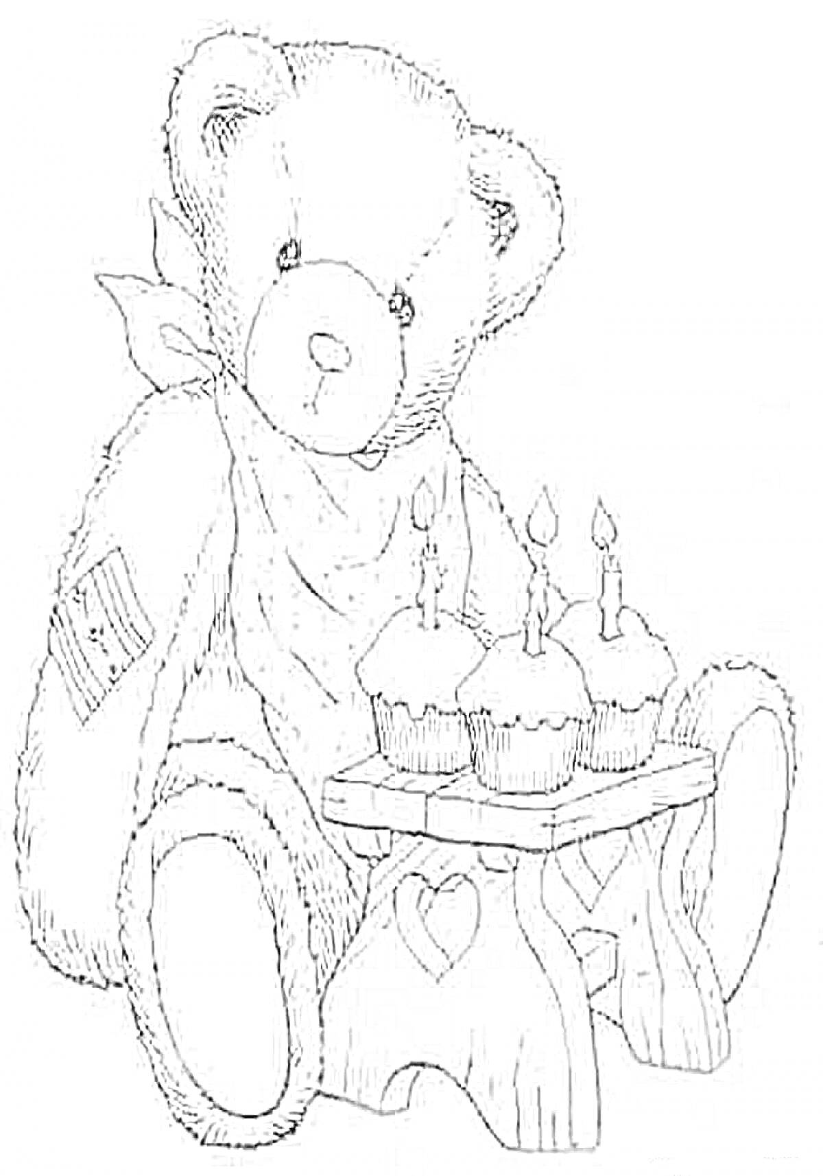 Мишка Тедди с повязкой на шее и заплаткой на плече, сидит с праздничным столом на котором три свечи вставлены в кексы