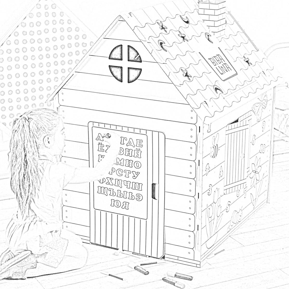 Раскраска Картонный игровой домик с рисунками на стенах, окошками и кирпичной трубой, девочка разукрашивает дверь, вокруг разбросаны карандаши.