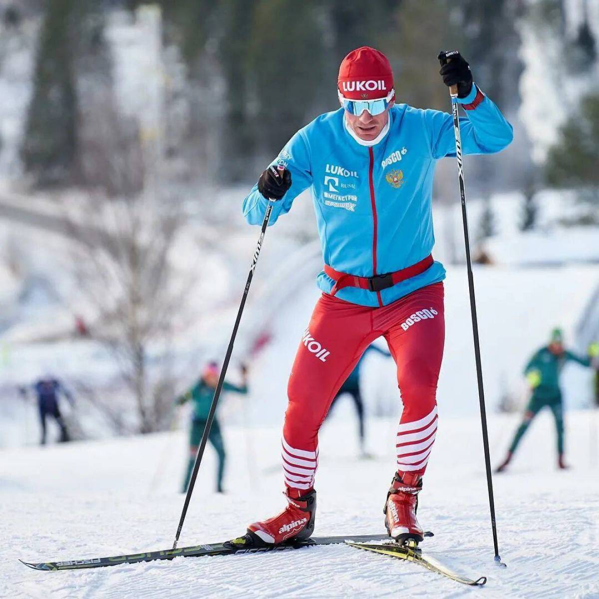 Три лыжных спортсмена. Холунд лыжник. Лыжный комбез Максима Вылегжанина.