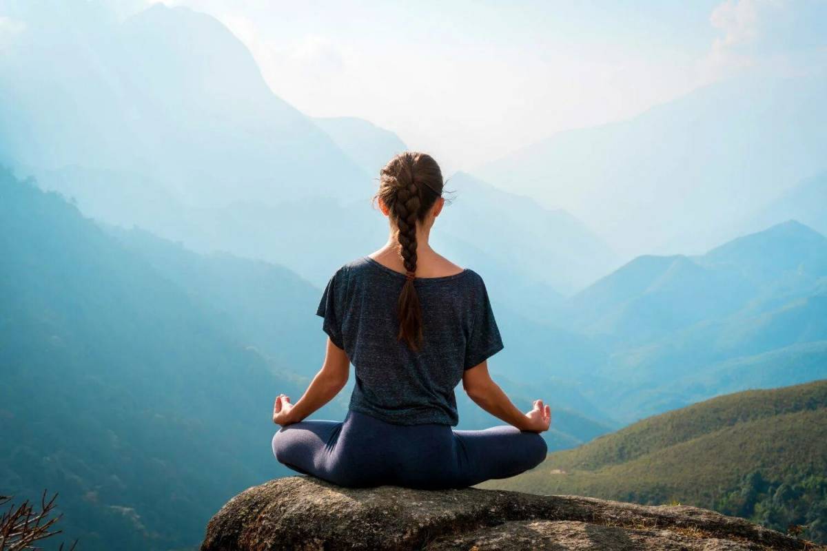 Медитация в горах. Девушка спокойствие. Девушка медитирует. Йога на вершине горы.