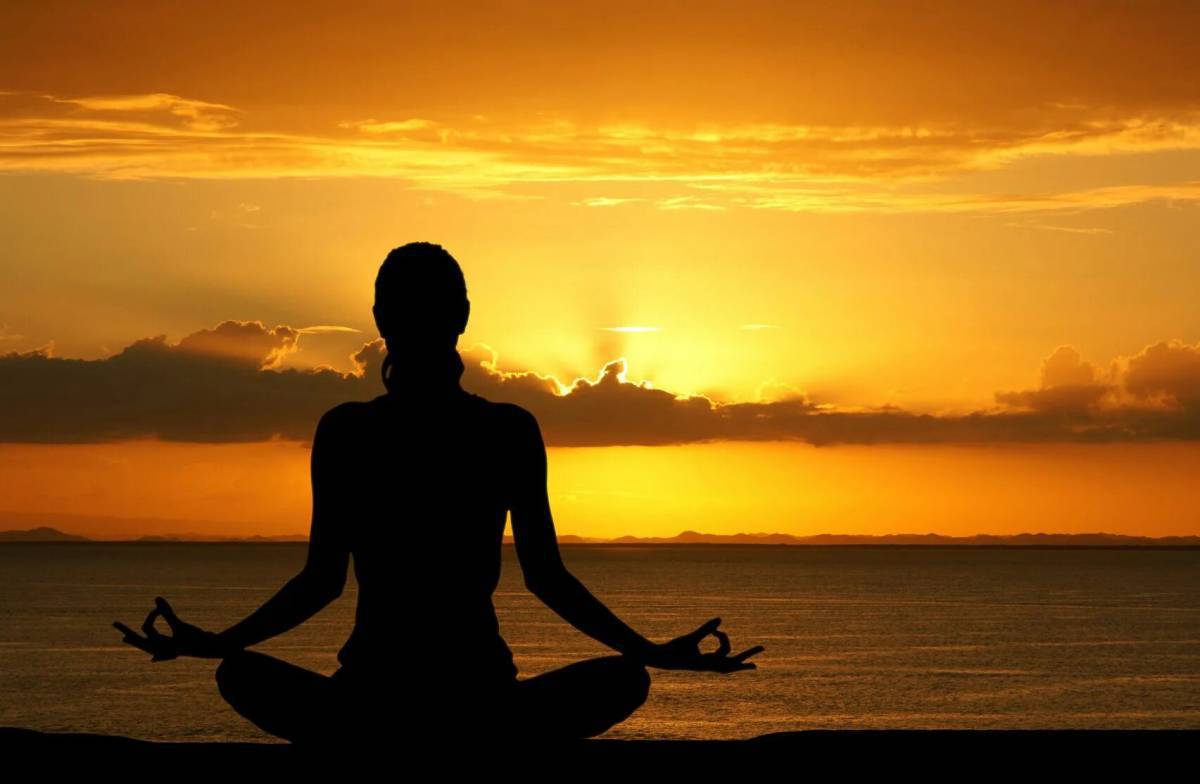 Группа релаксация. Йога на закате. Девушка медитирует на берегу. Йога море закат.